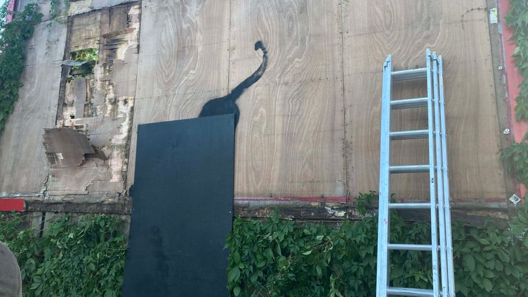 Contractors begin to dismantle a billboard in Cricklewood, north-west London, with the new Banksy artwork depicting a stretching cat that was unveiled on Saturday. The elusive street artist confirmed he was behind the piece, a silhouette of a large cat with an upturned tail stretching out its body. Picture date: Saturday August 10, 2024.

