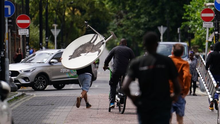 People remove a new artwork by Banksy, depicting a howling wolf painted on a satellite dish that was placed on a shop roof in Peckham, south London. The artist’s latest artwork comes a day after he unveiled three monkeys painted on a bridge in Brick Lane, east London. Picture date: Thursday August 8, 2024.

