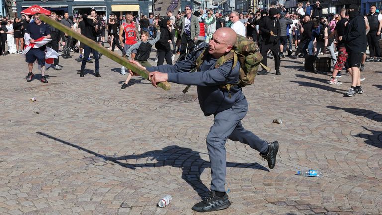 A man swings a length of wood as people protest in Blackpool, following the stabbing attacks on Monday in Southport, in which three young children were killed. Picture date: Saturday August 3, 2024.

