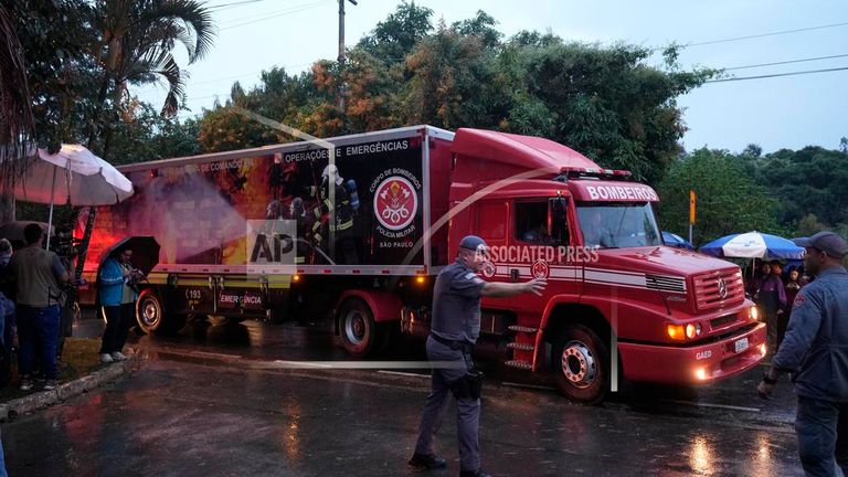 A refrigerated truck from the fire department arrives at the gated community where the crash took place. Pic: AP