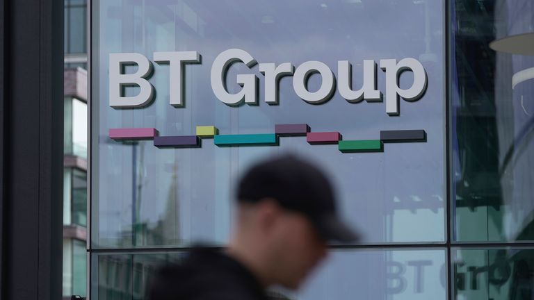 A man walks in front of the BT headquarters, in London, Thursday, May 18, 2023. U.K. telecom company BT Group said Thursday that it plans to shed up to 55,000 jobs by the end of the decade as part of an overhaul aimed at slimming down its workforce to slash costs. (AP Photo/Kin Cheung)