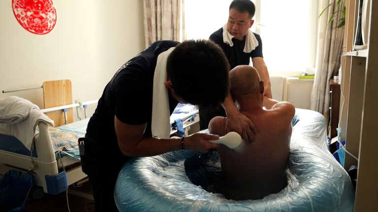 Yao Pei jiu being bathed at his home in Beijing