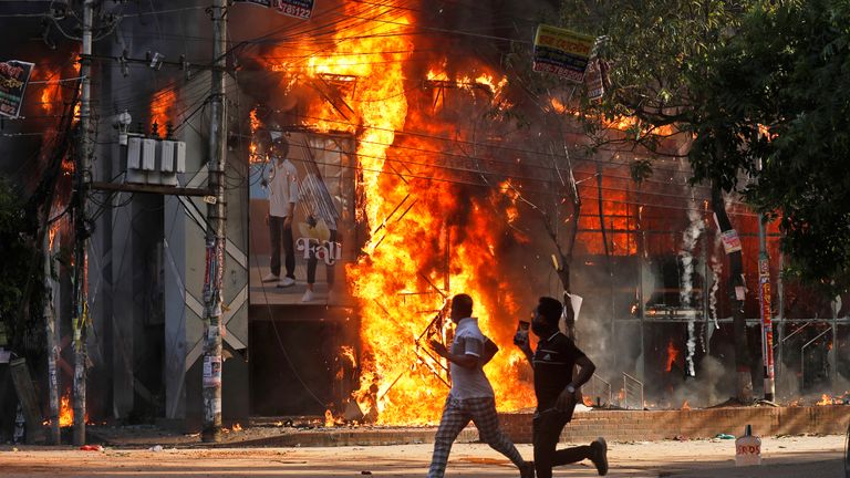 A shopping center was set on fire by protesters during a rally against Ms Hasina on Sunday. Pic: AP
