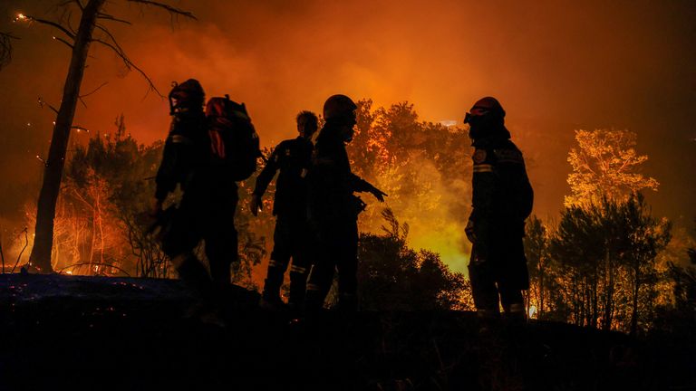 Firefighters try to extinguish a wildfire burning in Dionysos.
Pic: Reuters