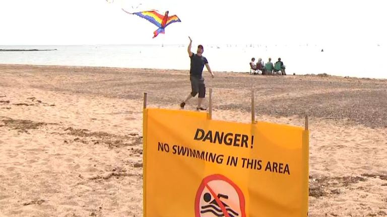 Signs warn people not to go into the sea