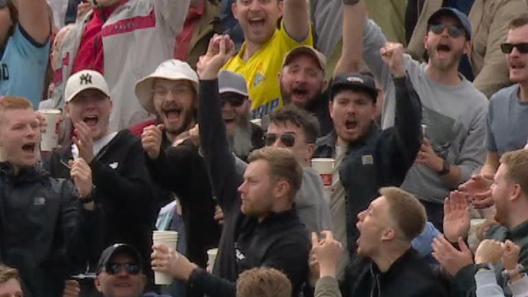 A man effortlessly raised his right arm and catched the ball out of the sky to huge roars from those around him.