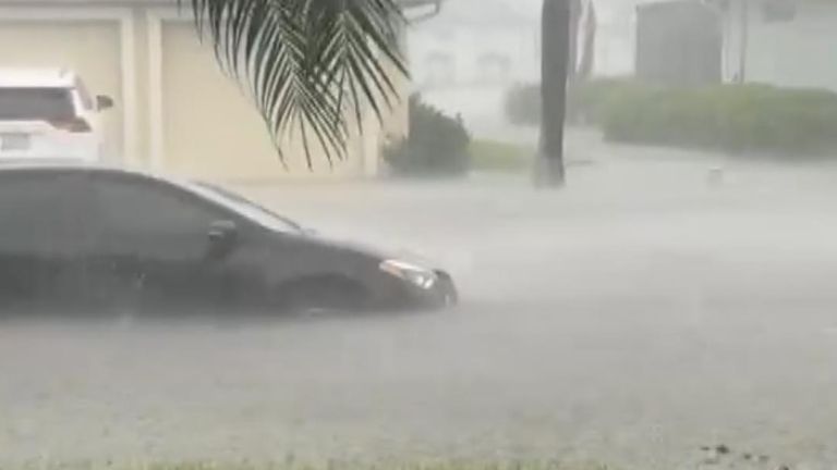 Car partially submerged in floods after Hurricane Debby
