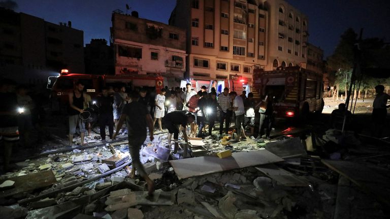 Palestinians gather at the site of an Israeli strike at a house in Gaza.
Pic: Reuters