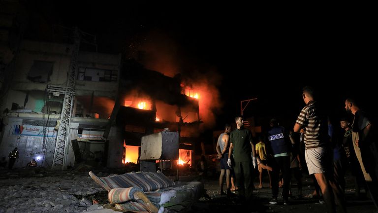 Palestinians gather at the site of an Israeli strike at a house in Gaza.
Pic: Reuters