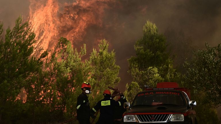 Firefighters try to extinguish a wildfire burning in the village of Varnavas, near Athens, Greece, August 11, 2024. Michalis Karagiannis/Eurokinissi via REUTERS ATTENTION EDITORS - THIS IMAGE HAS BEEN SUPPLIED BY A THIRD PARTY. NO RESALES. NO ARCHIVES. GREECE OUT. NO EDITORIAL OR COMMERCIAL SALES IN GREECE.