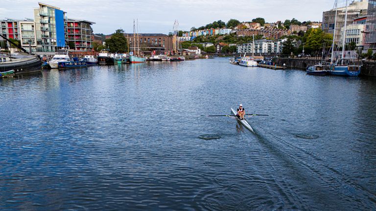 A rower pulls across the water on Bristol Harbourside in the early morning sun.
Pic: PA