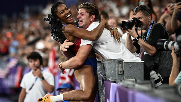 Tara Davis-Woodhall celebrates gold long jump win with husband Hunter Woodhall. Pic: Reuters