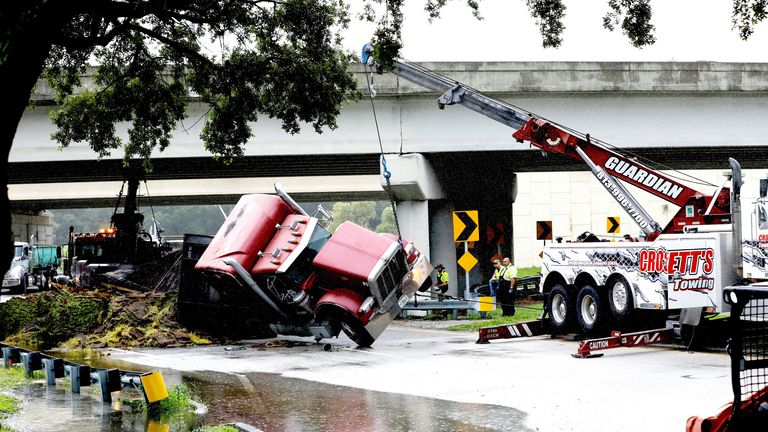 Tow trucks lift a transfer truck that overturned on Independence Parkway in Tampa as Hurricane Debby moves north of central Florida, U.S., August 5, 2024. REUTERS/Octavio Jones
