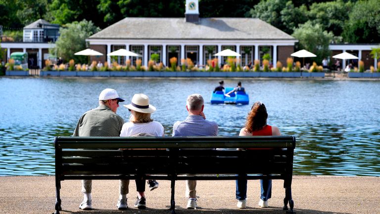 Morning visitors observe pedalo riders by the Serpentine in Hyde Park, London, on Tuesday. Pic: PA