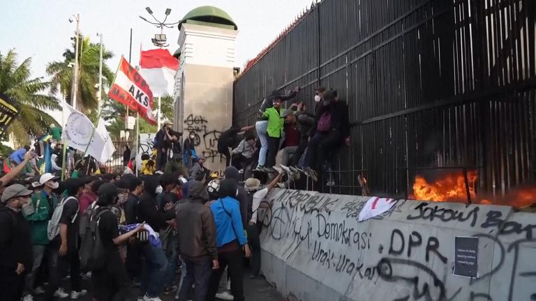 Protesters tore down a section of fence and threw stones at police in an attempt to storm parliament.