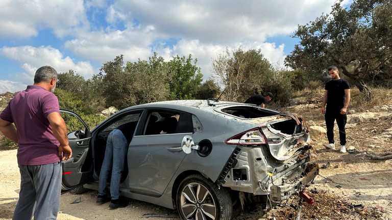 Palestinians assess the damage of a car during a military operation by Israeli forces near Jenin. Pic: Reuters