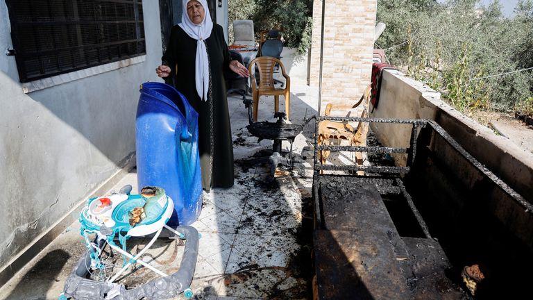 Palestinian woman stands in a home damaged during an attack in the village of Jeit.
Pic: Reuters