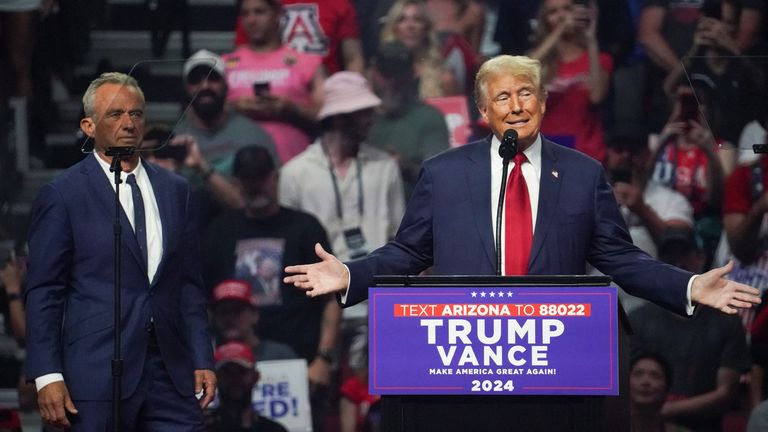 Republican presidential nominee and former U.S. President Donald Trump speaks during a rally as former independent presidential candidate Robert F. Kennedy Jr. looks on in Glendale, Arizona, U.S., August 23, 2024. REUTERS/Go Nakamura