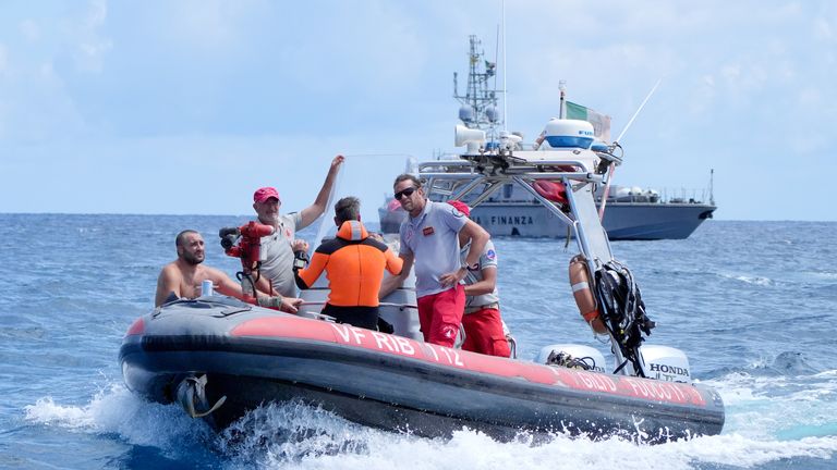 An Italian fire service diving crew return to Porticello Harbour.
Pic: PA