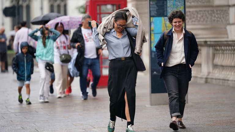 People walking in a rain shower on Whitehall in Westminster, London. Thunderstorms and hailstorms are set to sweep across parts of the UK on Thursday as temperatures reach up to 30C. Picture date: Thursday August 1, 2024. Pic: PA 