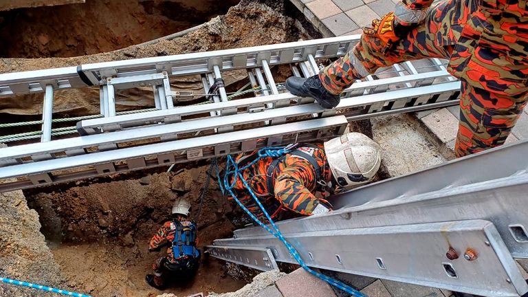 Rescue personnel entering the sinkhole on 23 Aug. Pic: AP
