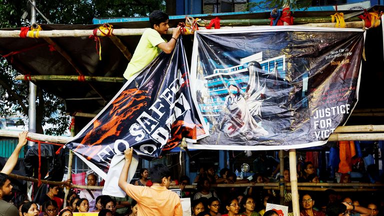 A medic ties a banner as they attend a protest following the rape and murder of a trainee doctor, inside the premises of R G Kar Medical College and Hospital in Kolkata.
Pic: Reuters