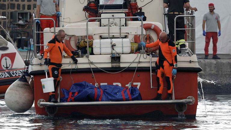 Rescue personnel work near a body bag containing the corpse of British entrepreneur Mike Lynch, who died when a yacht owned by his family sank off the coast of Porticello, near the Sicilian city of Palermo, Italy, August 22, 2024. REUTERS/Louiza Vradi