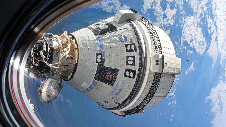 This photo provided by NASA shows Boeing's Starliner spacecraft, which carried astronauts Butch Wilmore and Suni Williams to the International Space Station, docked to the forward port of the Harmony module on July 3, 2024, as seen from a window of the SpaceX Dragon Endeavour spacecraft docked to the adjacent port. (NASA via AP)