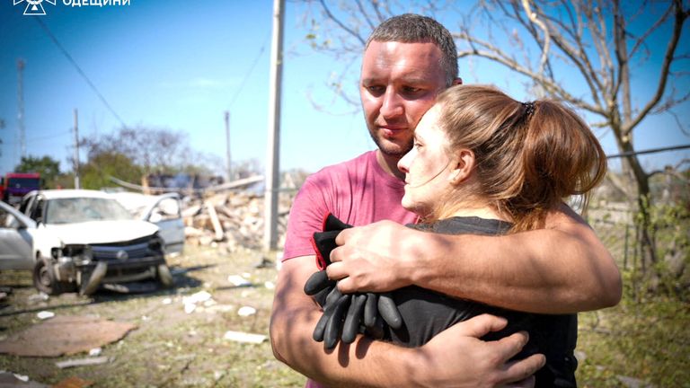 Local residents embrace each other at the site of a Russian missile strike in Odesa,
Pic:Emergency Service of Ukraine in Odesa/Reuters