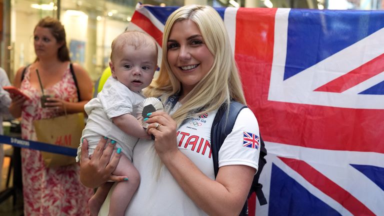 Amber Rutter with son Tommy and her silver medal from the Women's Skeet shooting after they arrive by Eurostar into London St. Pancras International train station after competing at the 2024 Paris Olympic Games in France. Picture date: Monday August 12, 2024. Jordan Pettitt/PA Wire