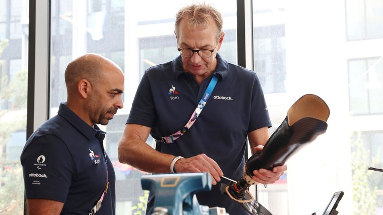 Two workers at a repair service centre for prosthetic limbs in the athlete village at the Paralmypics. Pic: AP