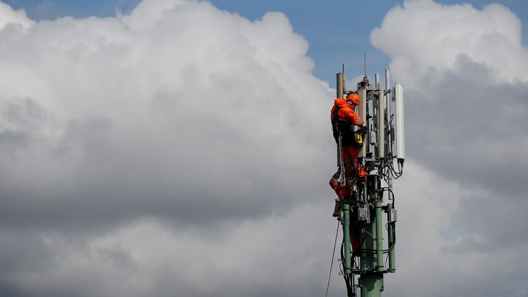 Communication engineers work on a mobile phone mast near Knutsford, northern England, April 8, 2016. REUTERS/Phil Noble