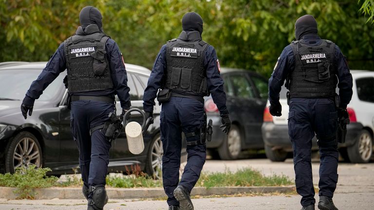 Police hold a battering ram outside the home of  Andrew Tate.
Pic: AP