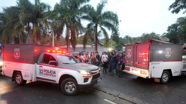 Police vehicles used to carry bodies arrive at the gated community where the plane crashed. Pic: AP