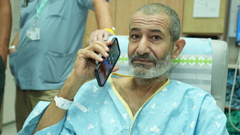 Qaid Farhan Alkadi uses his phone as he is reunited with loved ones after being rescued.
Pic Government Press Office/Reuters