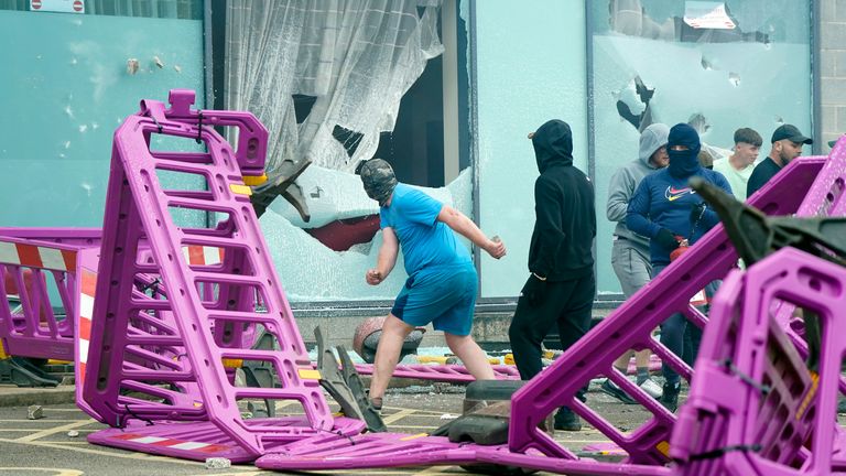 Windows are smashed as trouble flares during an anti-immigration protest outside the Holiday Inn Express in Rotherham, South Yorkshire. Picture date: Sunday August 4, 2024. PA Photo. See PA story POLICE Southport. Photo credit should read: Danny Lawson/PA Wire