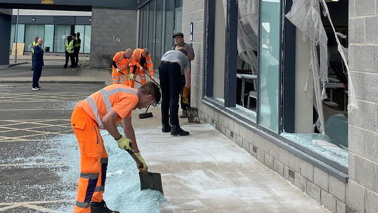 People clear the wreckage of the Holiday Inn Express in Rotherham, South Yorkshire, where anti-immigration protesters smashed the windows before starting fires on Sunday. At least 10 officers were injured, including one who was knocked unconscious, South Yorkshire Police later confirmed, saying one person had already been arrested and others involved should "Hope we are at your doors very soon". Photo date: Monday, August 5, 2024. PA photo. See the history of PA POLICE Southport. Photo credit should be: Dave Higgens/PA Wire    