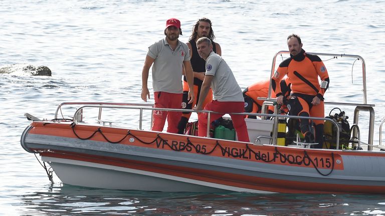 Italian firefighters scuba divers return to the harbor of Porticello, southern Italy, Tuesday, Aug. 20, 2024, as rescue teams returned to the site of a storm-sunken superyacht to search for six people, including British tech magnate Mike Lynch, who are believed to be still trapped in the hull 50 meters (164-feet) underwater. (AP Photo/Salvatore Cavalli)