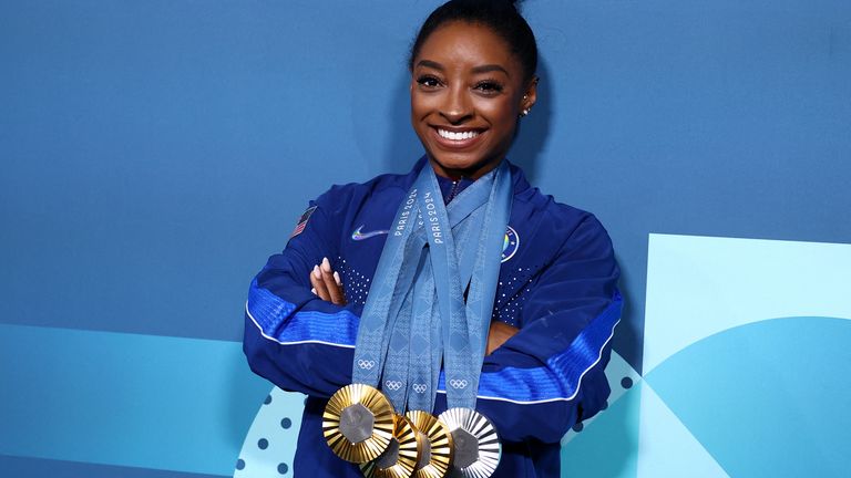 Simone Biles celebrates with her medals.
Pic:Reuters