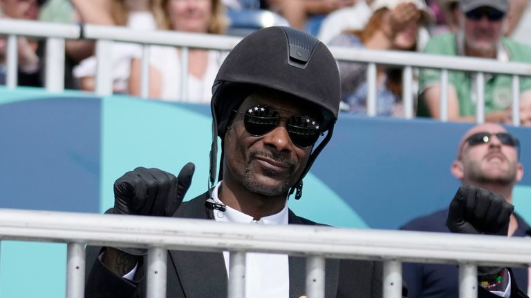 Snoop Dogg thumbs up as he watches the dressage team Grand Prix final at the 2024 Summer Olympics, Saturday, Aug. 3, 2024, in Versailles, France. (AP Photo/Mosa'ab Elshamy)