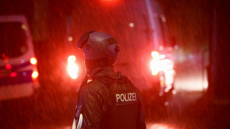 A police officer stands as a vehicle leaves the scene after a suspect was detained following the knife attack in Solingen. Pic: Reuters