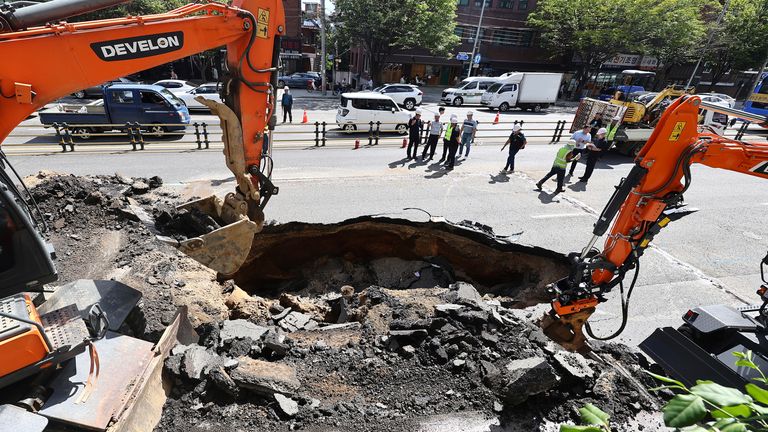 Rescue team work on the street restoration from a sinkhole area on a street in Seoul, South Korea.
Pic: Yonhap /AP