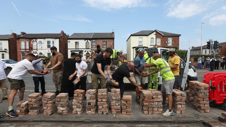 Volunteers rebuild the fence outside the mosque in Southport. Pic: PA