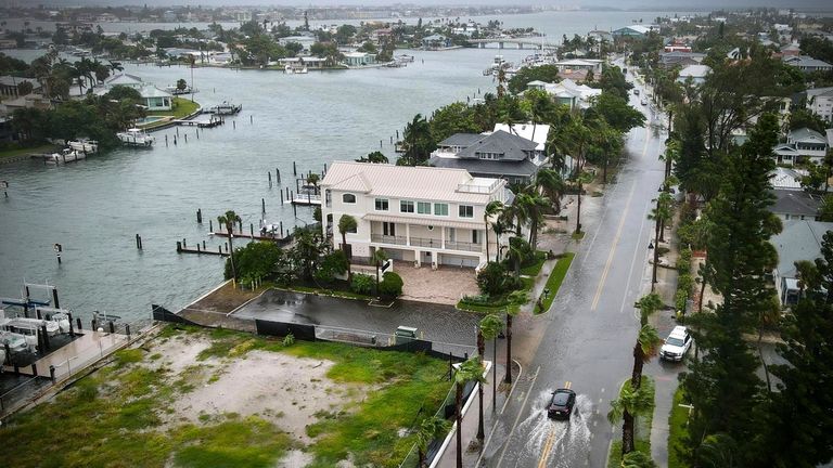 A driver negotiates a flooded street in Tampa Bay in Florida. Pic: AP