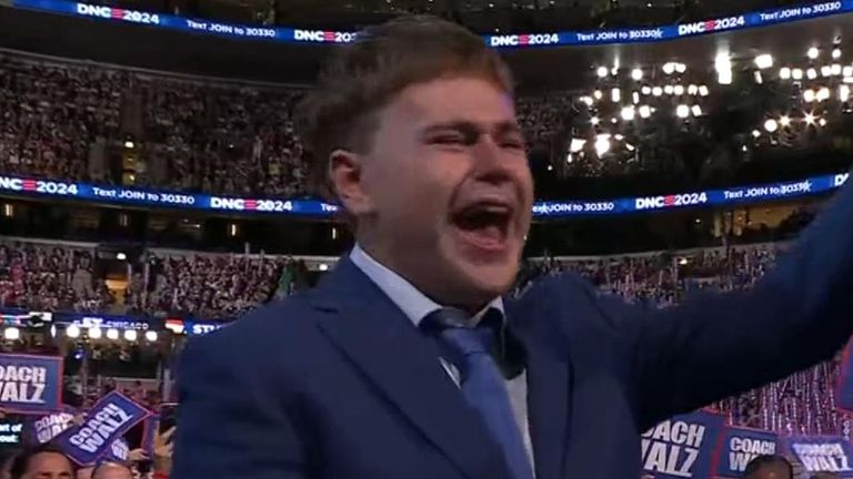 Gus Walz applauds his father Tim as he makes his speech at the DNC