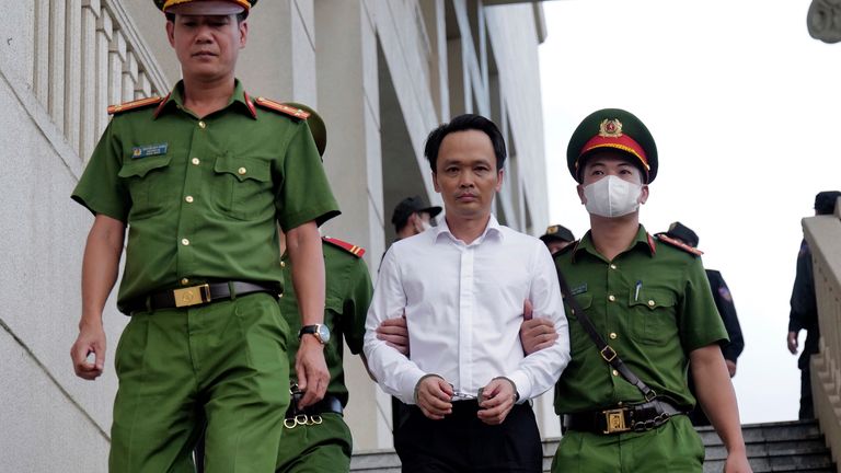 Trinh Van Quyet, a prominent Vietnamese business tycoon, is escorted out of a court after his trial in Hanoi, Vietnam, Monday, Aug.  5, 2024. Quyet was found guilty Monday of defrauding stockholders of nearly $150 million by falsely inflating the value of his company, in a case that comes as the government cracks down on widespread corruption in the country.   (AP Photo/Anh Tuc)