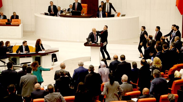 Turkey's AK Party lawmaker Alpay Ozalan scuffles with Workers' Party of Turkey (TIP) lawmaker Ahmet Sik, who was speaking during an extraordinary meeting of the Turkish parliament. Pic: Reuters