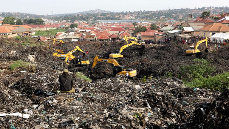 Onlookers watch as workers search for survivors at the site of a collapsed landfill in Kampala, Uganda, Sunday, Aug. 11, 2024. (AP Photo/Hajarah Nalwadda)