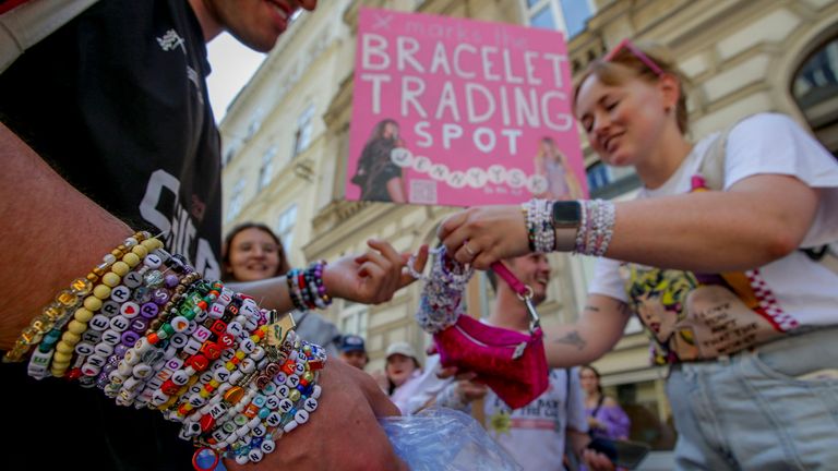 Swifties trade bracelets in the city centre in Vienna on Thursday, Aug.8, 2024. Organizers of three Taylor Swift concerts in the stadium in Vienna this week called them off on Wednesday after officials announced arrests over an apparent plot to launch an attack on an event in the Vienna area such as the concerts. (AP Photo/Heinz-Peter Bader)