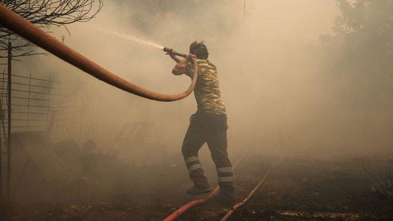 A volunteer tries to extinguish a wildfire burning in Nea Penteli, Greece.
Pic: Reuters